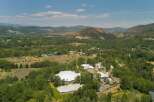 Discover this expansive property nestled in a picturesque valley, featuring a striking white domed structure and multiple modern buildings.