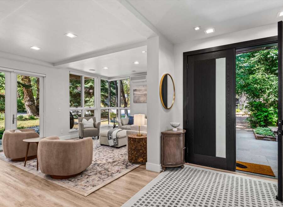 Step into a bright and airy living space featuring large windows that flood the room with natural light and offer serene views of the surrounding greenery.