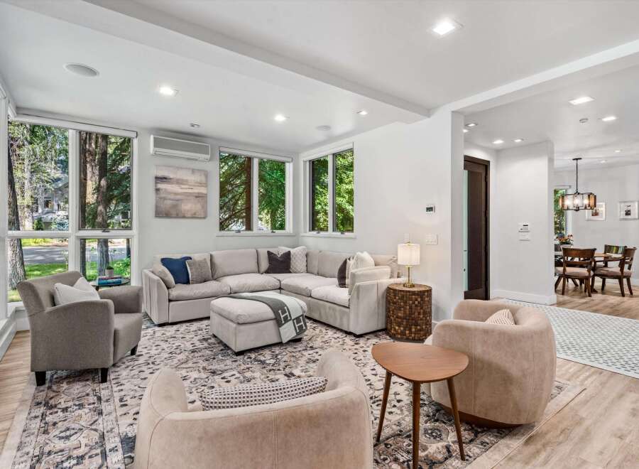 Experience modern living in this spacious living room, featuring a large sectional sofa and comfortable armchairs perfect for relaxation.