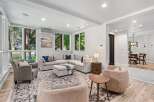 Experience modern living in this spacious living room, featuring a large sectional sofa and comfortable armchairs perfect for relaxation.