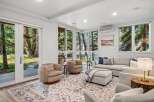 Experience seamless indoor-outdoor living in this beautifully appointed living room, featuring expansive windows and glass doors that invite the serene natural surroundings inside.
