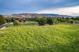 Experience the serene beauty of this expansive rural property, featuring lush green pastures bordered by a classic white fence.