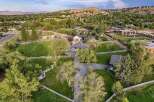 Discover this expansive estate featuring a charming main residence with a spacious driveway and a detached garage, all set against a backdrop of rolling hills and mature trees.
