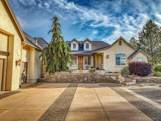 Discover this charming home featuring a welcoming facade with a stone retaining wall and a beautifully landscaped yard.