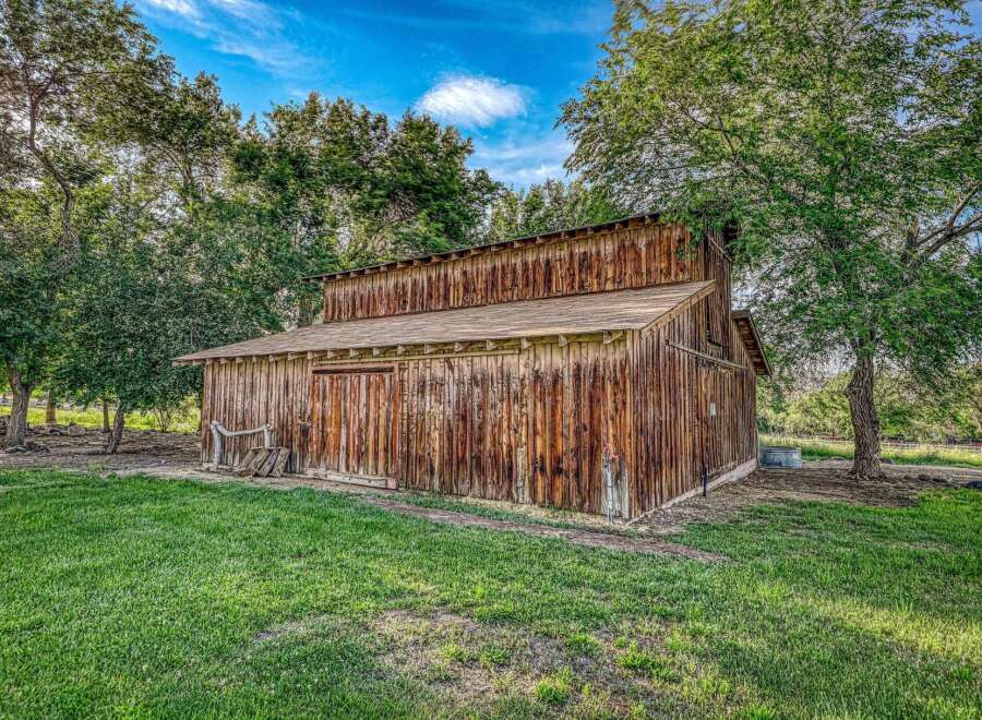 Discover rustic charm with this classic wooden barn, nestled amongst mature trees.