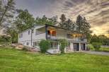 Discover this charming white home featuring a spacious wrap-around balcony perfect for enjoying the serene surroundings.