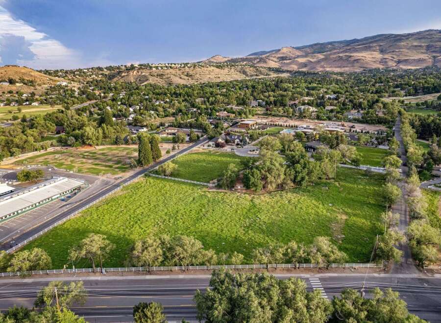 Discover this expansive property featuring lush green fields, mature trees, and picturesque white fencing, offering a serene and private setting.