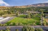Discover this expansive property featuring lush green fields, mature trees, and picturesque white fencing, offering a serene and private setting.