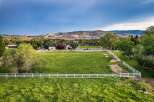Discover this stunning property featuring a sprawling green lawn enclosed by a pristine white fence, offering a picturesque setting for outdoor activities.