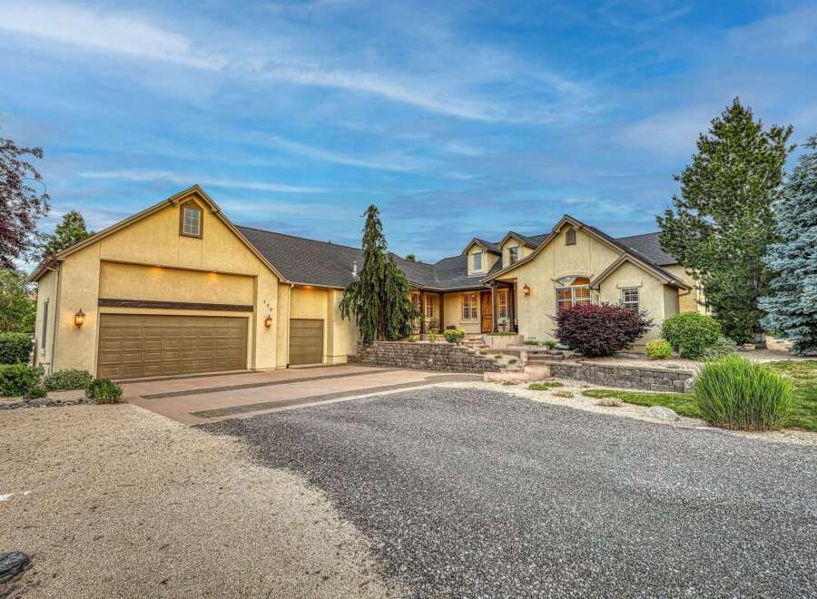 Discover this stunning home featuring a welcoming facade with a multi-car garage and a beautifully landscaped entrance.