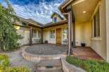 Welcome guests to this charming home with a welcoming courtyard entrance featuring a paved patio and comfortable seating areas.