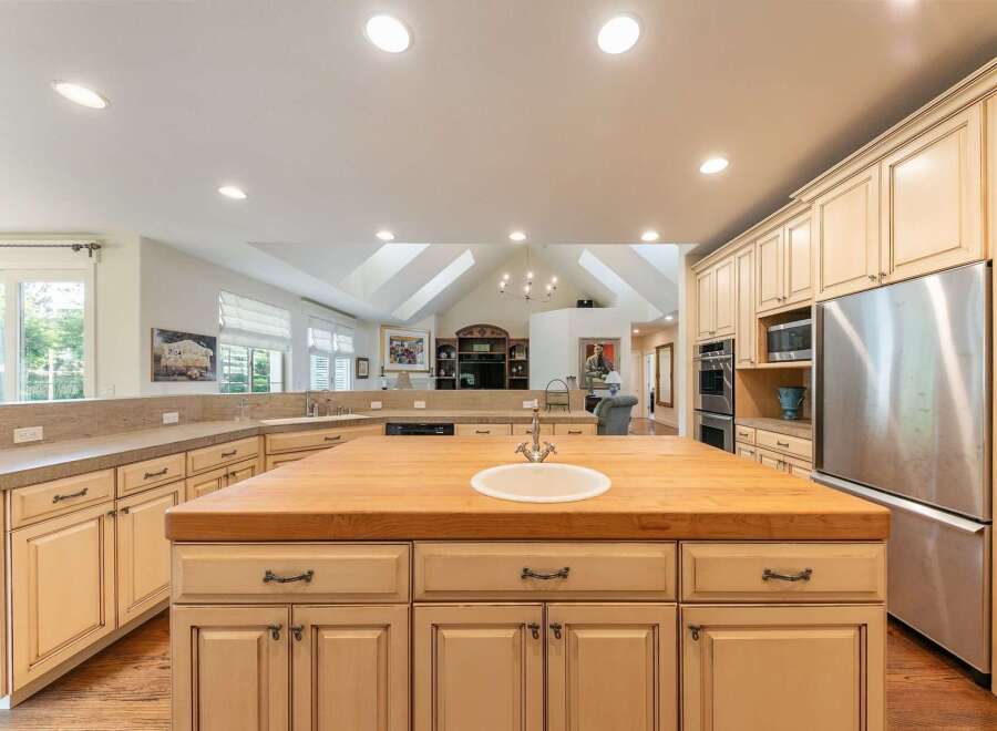Experience the heart of this home with a spacious kitchen featuring a large butcher block island with a built-in sink, perfect for meal preparation and casual dining.