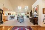 This spacious living room boasts a vaulted ceiling with skylights, a cozy fireplace, and elegant built-in shelving.