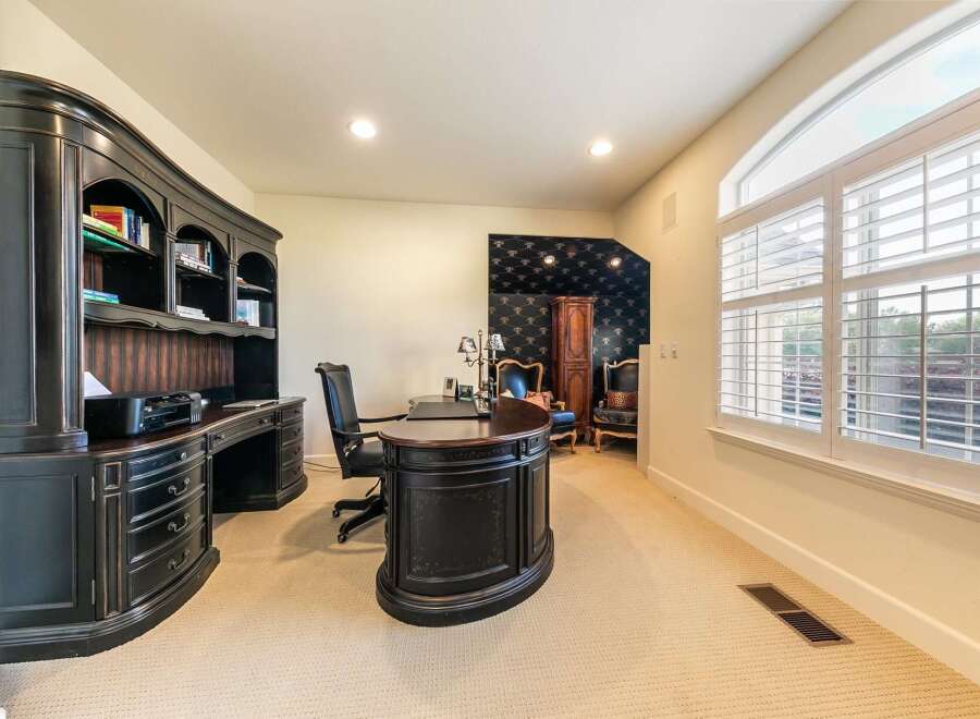 This elegant home office features a large, dark wood executive desk with a matching hutch and chair, perfect for productivity.