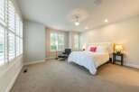 Experience ultimate comfort in this luxurious bedroom, featuring a plush white duvet, a striking tufted headboard, and a vibrant coral accent pillow.