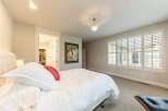 Experience luxury in this master bedroom, featuring a plush king-sized bed with crisp white linens and a vibrant red accent pillow.