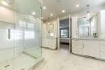 Experience luxury in this stunning master bathroom featuring a spacious glass-enclosed shower with a rainfall showerhead and a built-in bench.