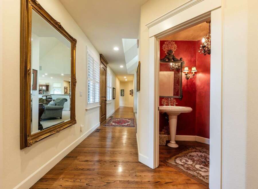 Step into a grand hallway featuring a large ornate mirror reflecting a spacious living area.