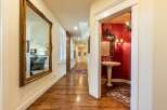 Step into a grand hallway featuring a large ornate mirror reflecting a spacious living area.