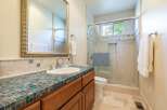 This beautifully appointed bathroom features a stunning mosaic tile countertop that adds a pop of color and texture.