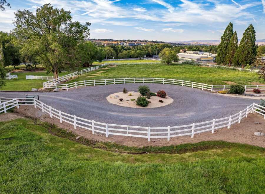Discover this stunning property featuring a circular gravel driveway with a charming landscaped island, perfect for welcoming guests.
