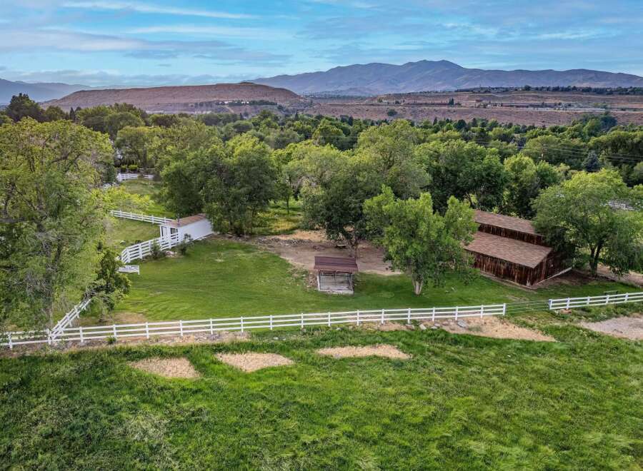 Discover this picturesque property featuring a charming white barn and a rustic wooden barn, perfect for equestrian enthusiasts or agricultural pursuits.