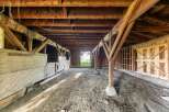 Explore the rustic charm of this spacious barn, featuring sturdy wooden beams and a durable dirt floor, perfect for agricultural use or conversion into a unique living space.