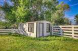 Discover this charming, rustic cabin nestled amidst lush greenery and mature trees.