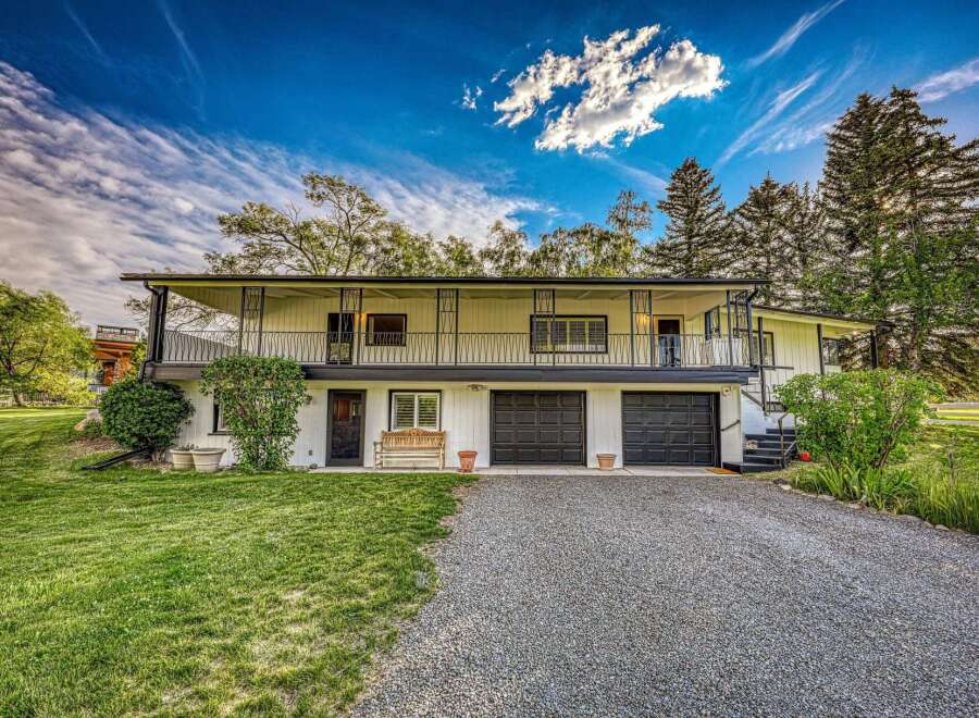 Discover this charming multi-level home featuring a spacious balcony with decorative railings, perfect for enjoying the serene surroundings.