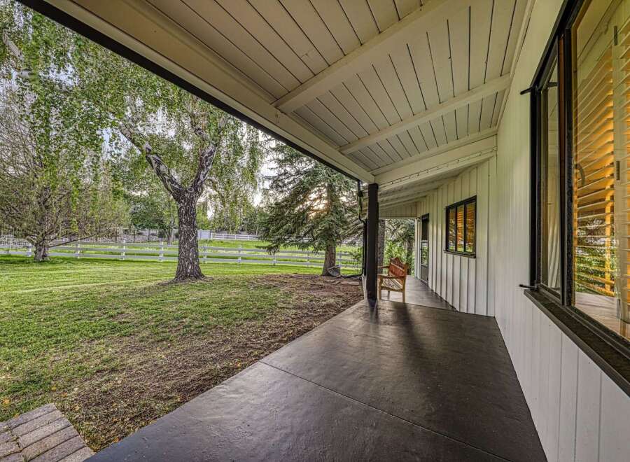 Enjoy the serene outdoors from the covered porch of this charming home.