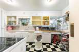 Step into this charming kitchen featuring a classic black and white checkered floor and ample white cabinetry.