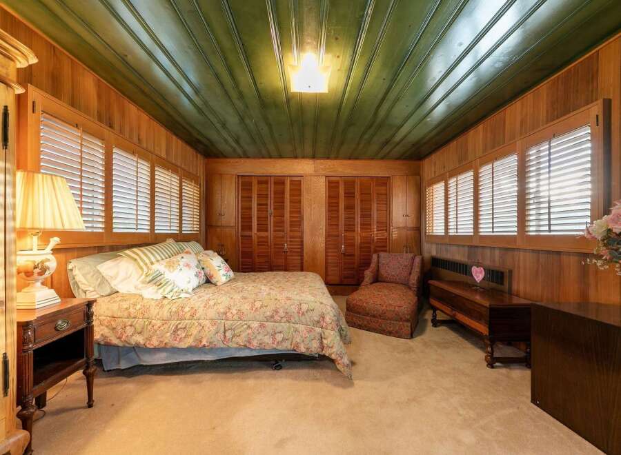 Step into a charming bedroom featuring a cozy bed adorned with floral linens and accent pillows.