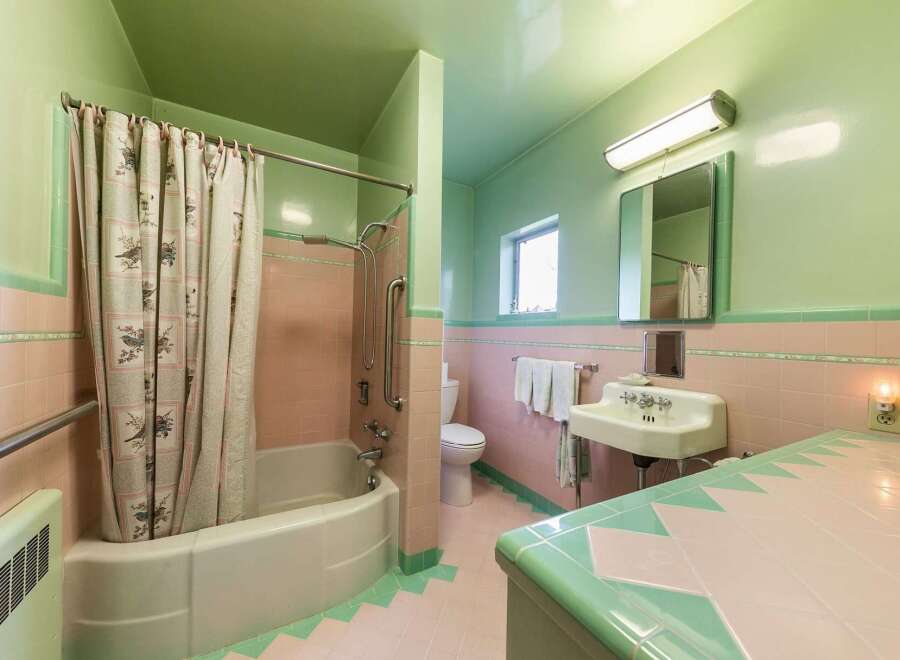 Step back in time with this charming retro bathroom, featuring a classic pink and mint green tile scheme.