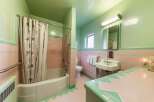 Step back in time with this charming retro bathroom, featuring a classic pink and mint green tile scheme.