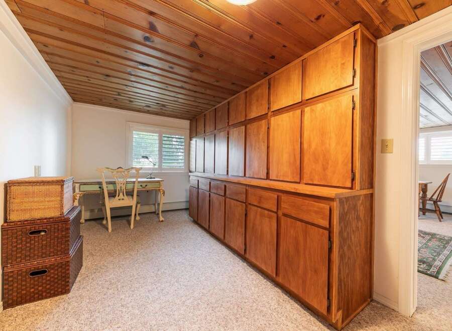 This room features a stunning floor-to-ceiling wooden cabinet system, offering ample storage and a warm, natural aesthetic.