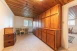 This room features a stunning floor-to-ceiling wooden cabinet system, offering ample storage and a warm, natural aesthetic.