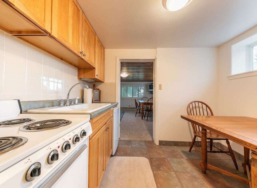 Discover this charming kitchen featuring warm wooden cabinetry and a classic white tiled backsplash.