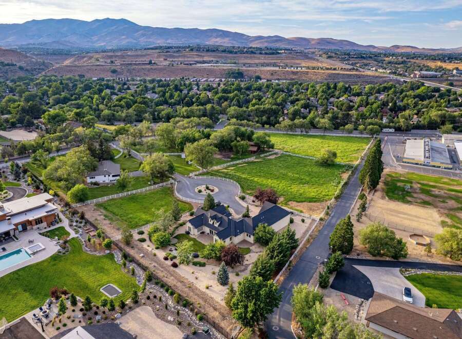 Experience luxury living in this expansive estate, featuring a modern home with a stunning pool and spa, surrounded by lush greenery and picturesque mountain views.