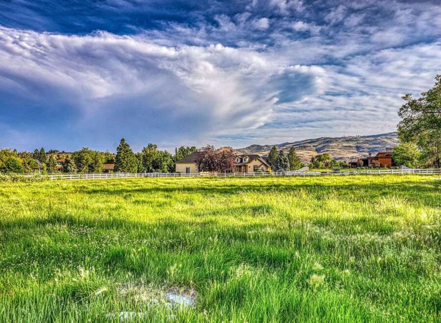 Experience luxurious country living in this stunning property, featuring a beautiful home nestled amidst lush greenery and rolling hills.