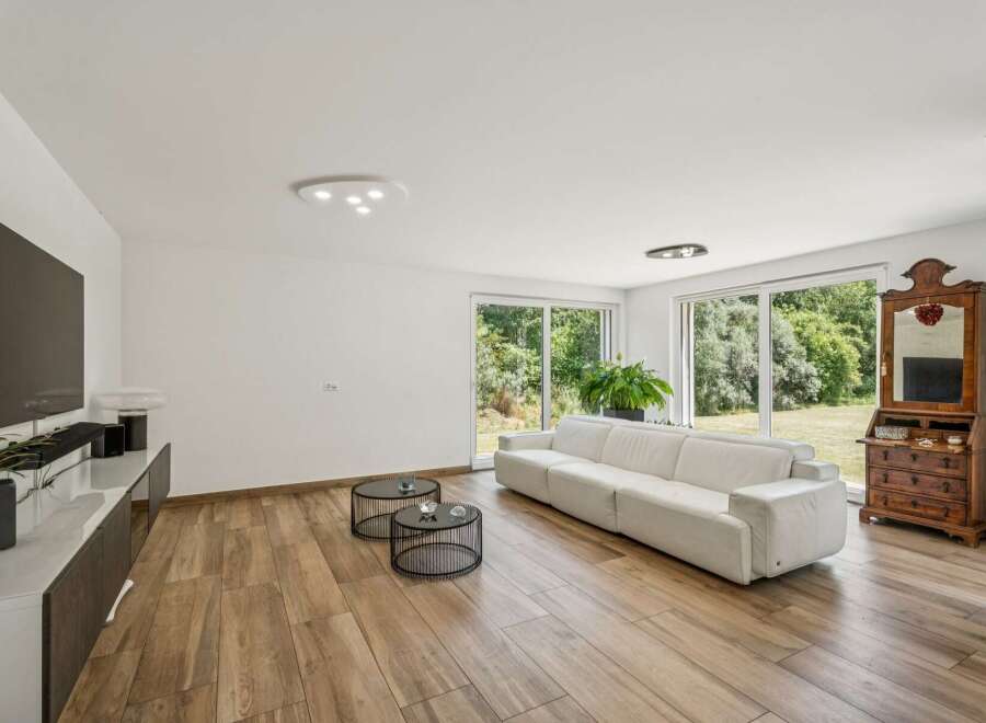 Experience modern living in this spacious living room featuring a plush white sectional sofa perfect for relaxation.