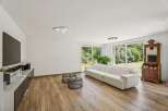Experience modern living in this spacious living room featuring a plush white sectional sofa perfect for relaxation.