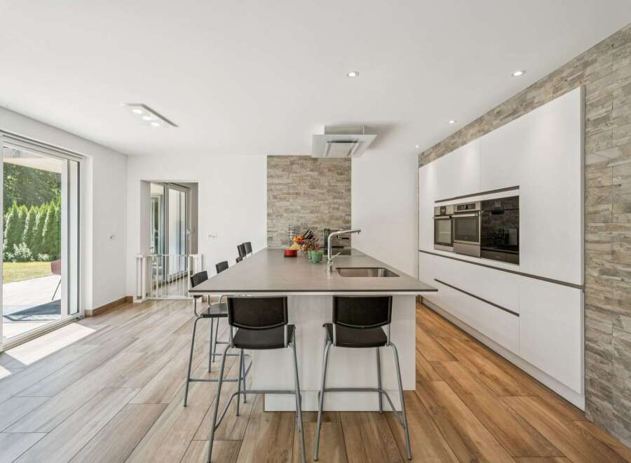 Experience modern living in this stunning kitchen featuring a sleek island with bar seating, perfect for casual dining and entertaining.