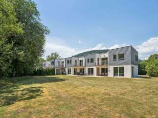 Discover modern living in this row of contemporary townhouses, featuring sleek grey siding and white stucco exteriors.