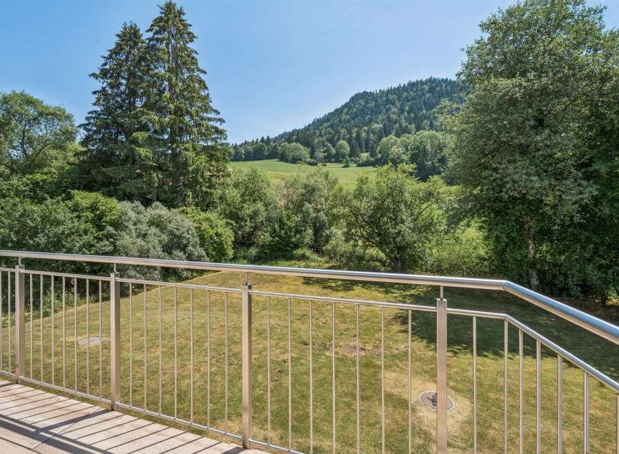 Enjoy breathtaking natural views from this property's balcony, featuring a modern stainless steel railing.