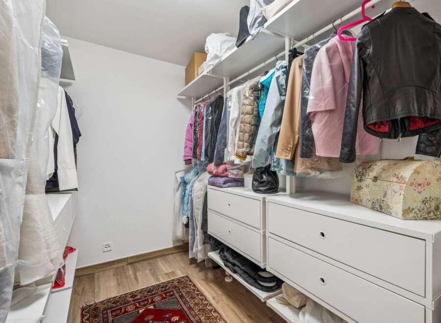Discover ample storage in this well-organized walk-in closet, featuring a comprehensive shelving system and multiple drawers.