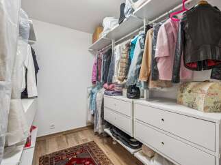 Discover ample storage in this well-organized walk-in closet, featuring a comprehensive shelving system and multiple drawers.