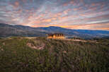 Experience breathtaking sunset views from this stunning mountain home, perched atop a lush hillside.