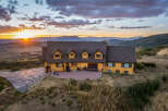 Experience breathtaking sunset views from this stunning log home, nestled amidst rolling hills and majestic mountains.