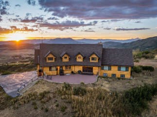 Experience breathtaking sunset views from this stunning log home, nestled amidst rolling hills and majestic mountains.