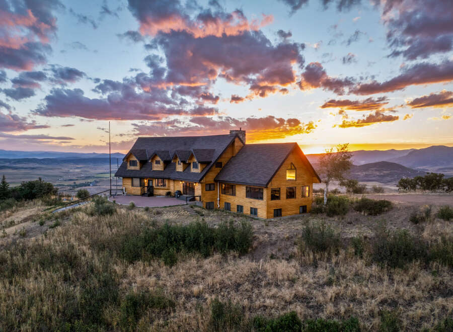 Experience breathtaking sunset views from this stunning log home, perched atop a hill with panoramic vistas of the valley and mountains.